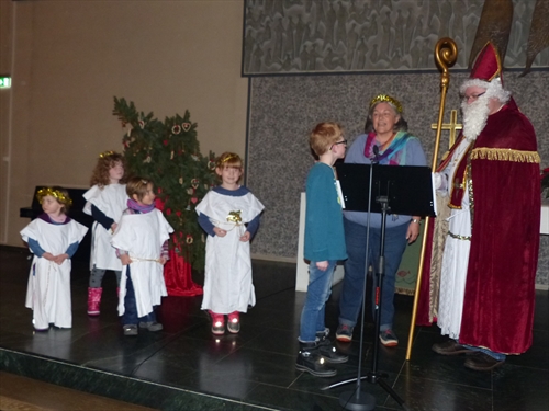 Der Nikolaus, auf den vor allem die Kleinen mit Spannung gewartet hatten, begleitet mit Engelchen und der Gemeindepädagogin Claudia Schönbeck, verteilten Geschenke an die Kinder (Foto: Weiland)
