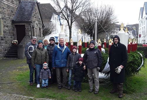 Das diesjährige Schmück-Team richtet den 4 Meter große Riesen-Wichernkranz vor der Ev. Erlöserkirche in Attendorn wieder ansehnlich her (Foto: Schliebener)