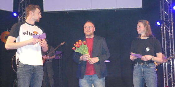 Jugendevangelisten Sven Körber zusammen mit den beiden Moderatoren, Mattis Rahn und Henrike Stöcker, die ihm „Blumen zum Valentinstag“ überreichten. (Foto: Ingrid Weiland)