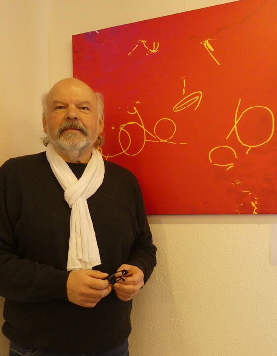 Bernhard Laß vor dem im Museum für Lichtkunst in Unna aufgenommenen Bild, auf dem er das sich auf dem Fußboden spiegelnde rote Licht fotografiert hat, das den ganzen Raum durchflutet. (Foto: Ingrid Weiland)