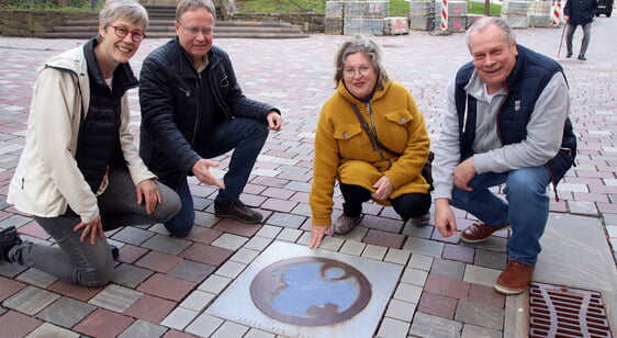 Der Engel der Kulturen, um den sich Manuela Behle, Pfarrer Achim Riggert, Christa Bätz und Stefan Schick versammeln, wurde am 9. November 2012 ins Pflaster der Wilhelmstraße eingelassen. Das Friedensgebet soll an das Zehnjährige dieses Ereignisses erinnern. (Foto: Jakob Salzmann)