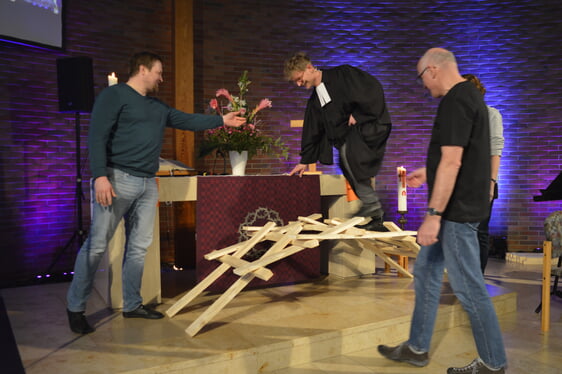 Stefan Pogorzelski, der Pfarrer der neuen Kirchengemeinde „ERlebt“ Lüdenscheid, ging im Festgottesdienst über eine Brücke aus Holz, die im Altarraum aufgebaut wurde. Die Brücke hielt und war so stabil, dass der Pfarrer unter großem Beifall der Anwesenden darüber gehen konnte (Foto: Kannenberg)