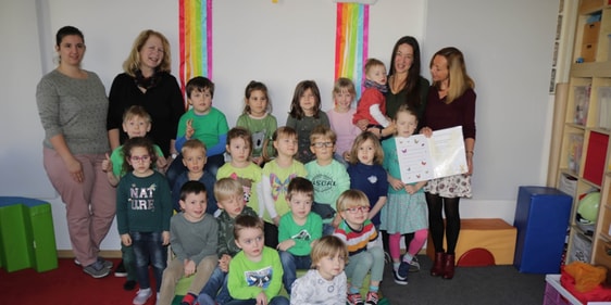 Die Kinder der Schäfchen-Gruppe feierten mit Leo (im roten T-Shirt auf dem Arm von Erzieherin Katia Vandefelde, Leiterin der Schäfchen-Gruppe) den Welt-Down-Syndrom-Tag (Foto: Görlitzer)