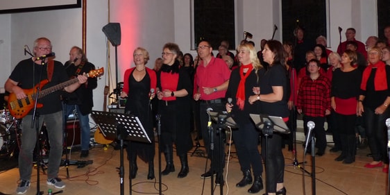 „20JRisecorn JostSolistin“ und „JostSolisten- Helmut Jost mit einer Chorsolistin bzw. mit allen Chorsolisten vor dem Geospelchor „Risecorn“ (Foto: Weiland)