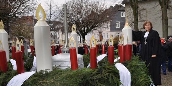 Dr. Annette Kurschus ließ es sich nehmen, selbst die erste Kerze am „Riesen-Wichern-Adventskranz“ vor der Attendorner Erlöserkirche zu entzünden (Foto: Ernst)