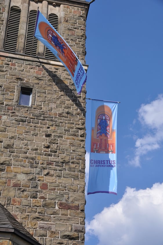 Der fahnengeschmückte Turm der Erlöserkirche in Attendorn an Ostern 2020 (Foto: Karl-Hermann Ernst)