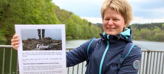 Tina Gieselmann, 2. Vorsitzende des CVJM Schalksmühle, hatte die Idee zu dem Pilgerweg an der Glör. Die neun Stationen baute der Verein am Donnerstag in Kleinstgruppen auf. Im Bild ist die Schautafel zum Thema "Felsen" zu sehen. (Foto: Jakob Salzmann)