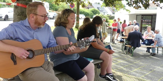 Am Abend setzte Gemeindepfarrer Sebastian Schultz dem Beisammensein vor der Markuskirche mit Gitarrenmusik und Gesang noch besondere Akzente auf. (Foto: Ingrid Weiland)