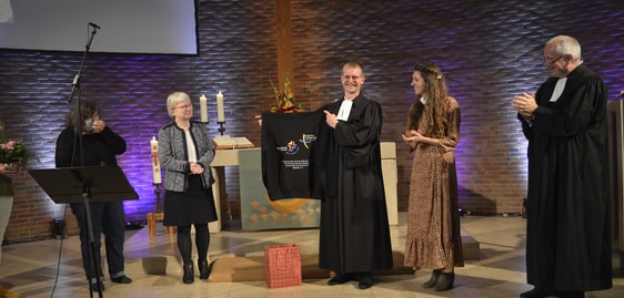 Steffen Pogorzelski (3.v.r) wurde zum Abschluss von beiden Presbyterien beschenkt: Ein Skater-Pullover mit den Logos beider Gemeinden. (Foto: Iris Kannenberg)
