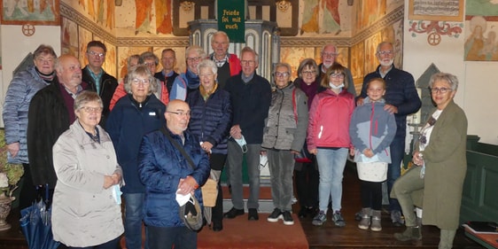 Die überregionale „Unter uns“-Gruppe des CVJM-Kreisverbandes Lüdenscheid ließ sich von Kirchenführerin Monika Kretschmer (ganz r.) die Wandmalereien in der der bunten Kirche in Lieberhausen erklären. (Foto: Ingrid Weiland)