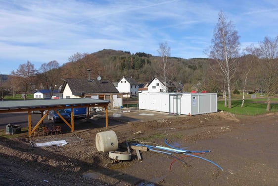 Von der bereits neu gebauten Brücke ist der Grundriss des alten Gemeindezentrums in Liers zu erkennen. Der Container ist vor einigen Wochen aufgestellt worden. (Foto: Julia Pütz)