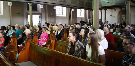 Die geöffneten Kirchentüren sorgten dafür, dass auch draußen auf dem belebten Kirchplatz jedes Wort zu hören war und Menschen in die Kirche gelockt wurden, die sie sonst nicht betreten würden. (Foto: Iris Kannenberg)