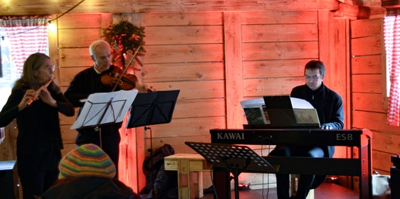 Advents-Gottesdienst in der „Weihnachtsalm“ auf dem Lüdenscheider Weihnachtsmarkt. Musikalisch begleitet Dmitri Gregoriev und dem Ehepaar Tometten. (Foto: Iris Kannenberg)